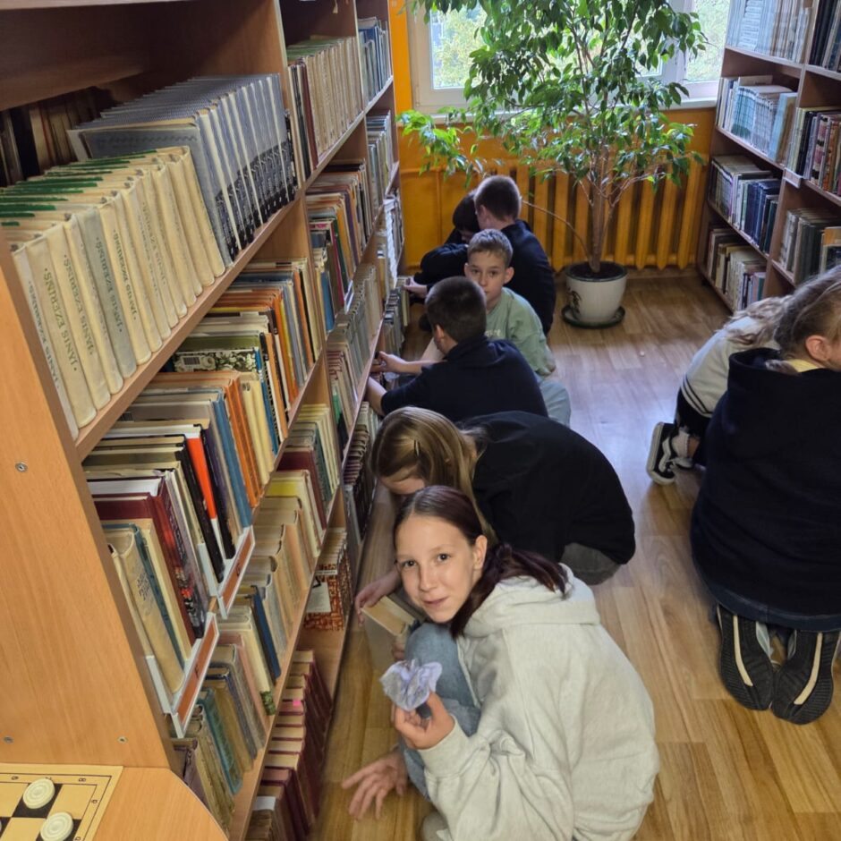 5.a klases skolēni čakli palīdz bibliotekārei rūpēties par grāmatām.