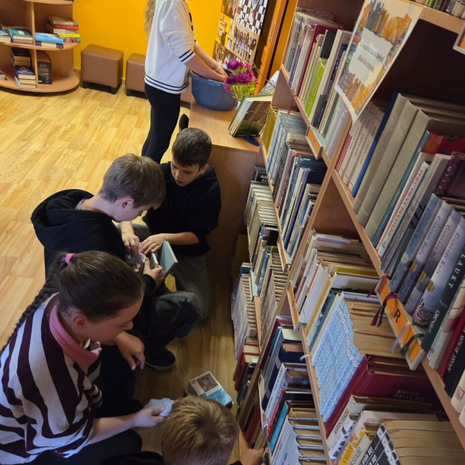 5.a klases skolēni čakli palīdz bibliotekārei rūpēties par grāmatām.